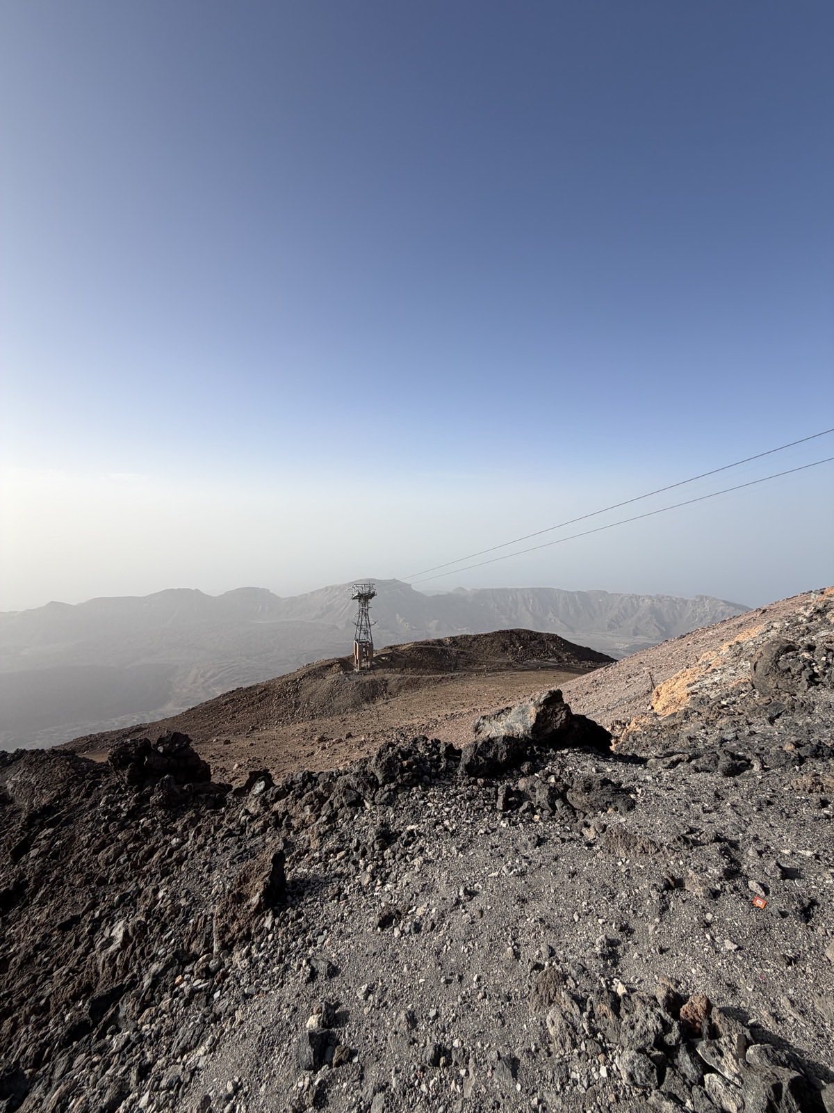 Teide cable car pylon on the volcanic ridge against a deep blue sky